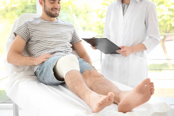 Ung man med bandagerade benet — Stockfoto