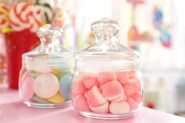 Tasty sweets in jars on table — Stock Photo, Image