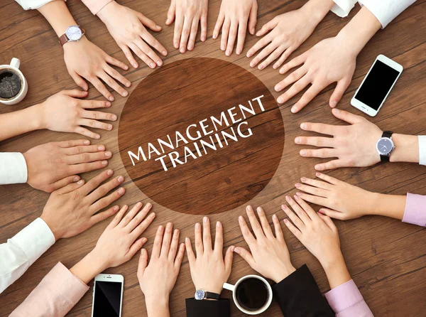Conceito de formação em gestão. Empresários de mãos dadas sobre mesa de madeira — Fotografia de Stock