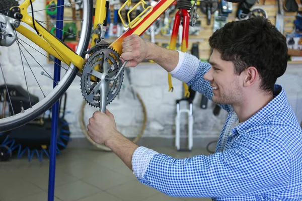 Man aan het werk in fiets reparatie winkel — Stockfoto