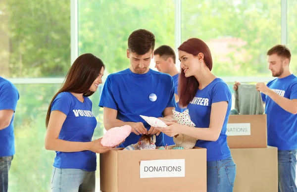 Νέοι εθελοντές με κουτί δωρεών σε εσωτερικούς χώρους — Φωτογραφία Αρχείου