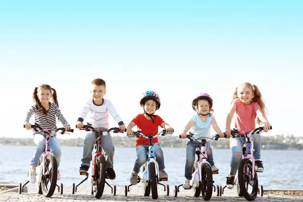 Leuke lieve kinderen, Fietsen in de buurt van rivier rijden op zonnige dag — Stockfoto