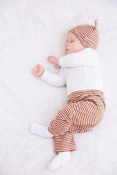 Mignon petit bébé dormant sur plaid à la maison — Photo