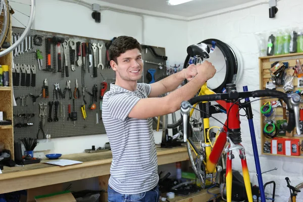 Man aan het werk in fiets reparatie winkel — Stockfoto