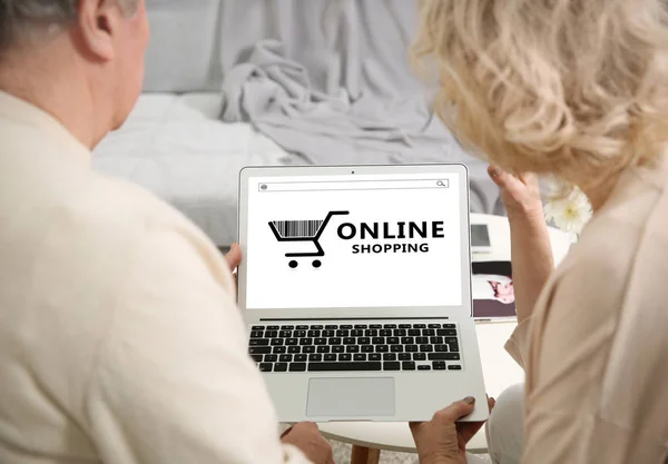 Concept de shopping sur Internet. Couple aîné utilisant un ordinateur portable à la maison — Photo