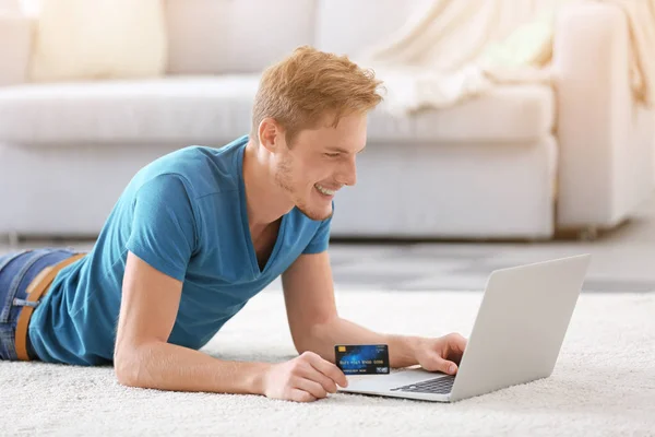 クレジット カードと自宅のラップトップの若い男 インター ネット ショッピング概念 — ストック写真