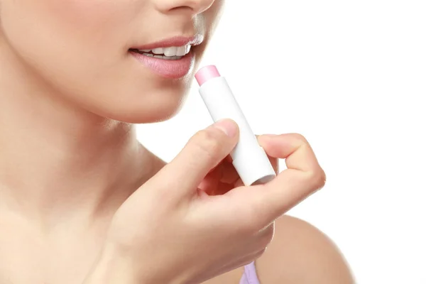 Vista de cerca de la hermosa mujer joven que aplica lápiz labial, fondo blanco — Foto de Stock