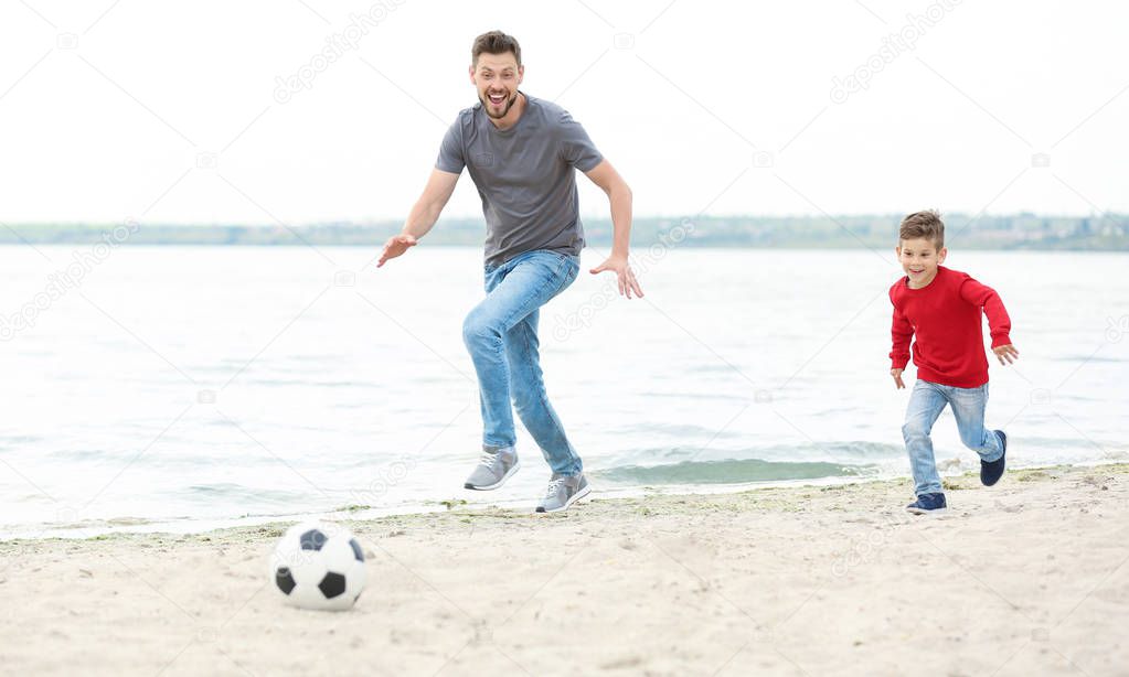 Dad and son playing football 