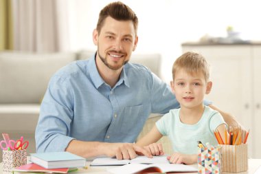 Baba ve oğul ödev yapıyor.