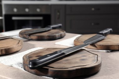 Bıçak ve ahşap tahta mutfak masasının üzerinde.