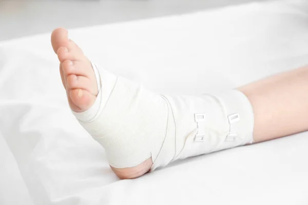 Junge Frau mit bandagiertem Bein — Stockfoto