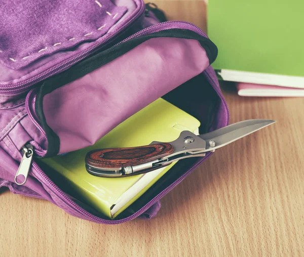 Mochila con cuchillo en el escritorio de la escuela — Foto de Stock