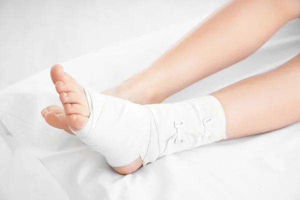 Young woman with bandaged leg — Stock Photo, Image
