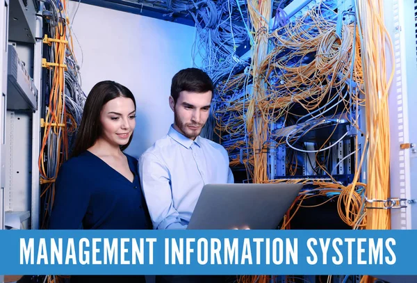 Concept of management information systems. Young engineers with laptop in server room