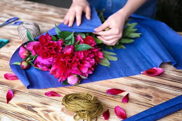 Fleuriste féminine faisant bouquet de belles pivoines — Photo