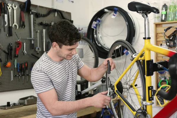 Uomo che lavora in officina di riparazione biciclette — Foto Stock