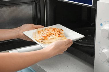 Lazanya tabak mikrodalga koyarak kadın 