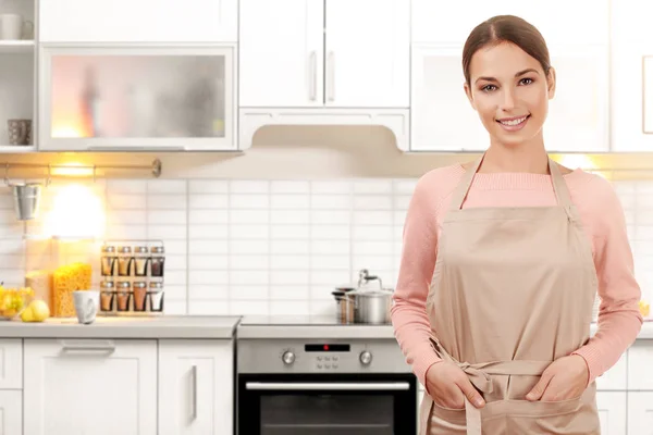 Jovem mulher no avental na cozinha em casa — Fotografia de Stock