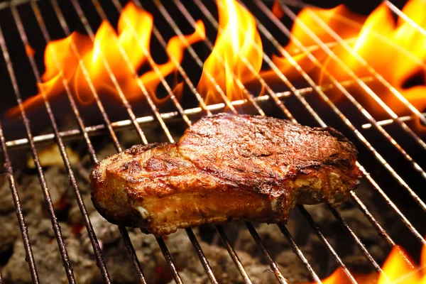 Bife delicioso na grelha e chama — Fotografia de Stock