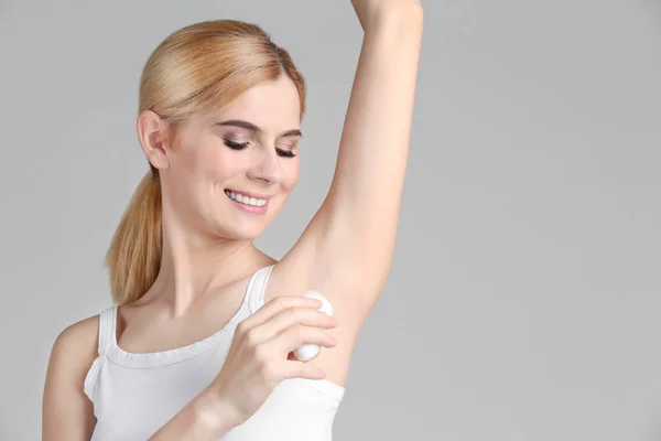 Mooie jonge vrouw met behulp van deodorant — Stockfoto