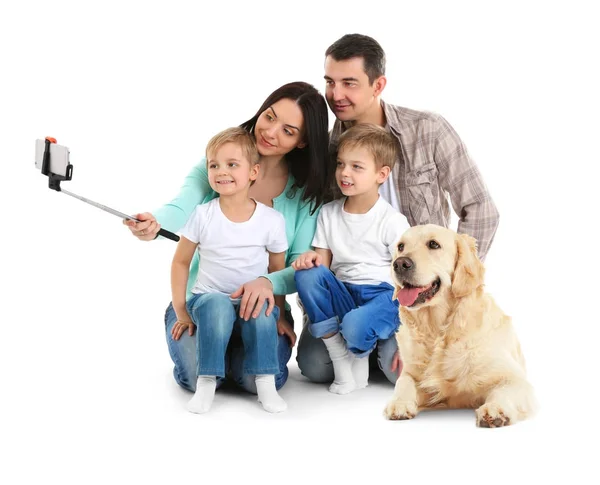 Família feliz tomando selfie com cão no fundo branco — Fotografia de Stock