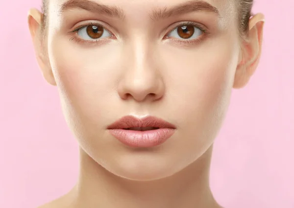 Primo piano vista di bella giovane donna con labbra naturali trucco su sfondo di colore — Foto Stock