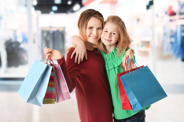 Mor och dotter med shoppingkassar i butik. Boxing Day koncept — Stockfoto
