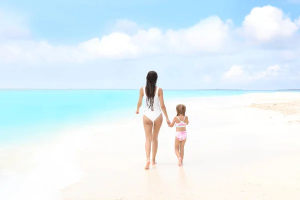 Vacker ung kvinna med sin dotter på stranden på sea resort — Stockfoto