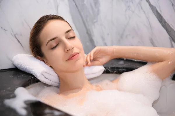 Женщина расслабляется в ванне с пеной — стоковое фото
