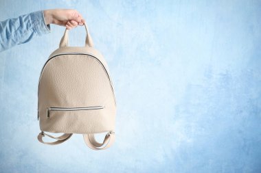 Deri sırt çantası tutan kadın
