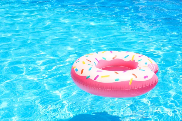 Inflatable colorful donut in pool — Stock Photo, Image