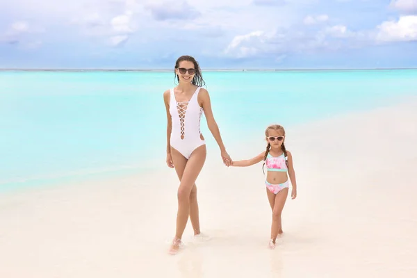 Kvinna med dotter på stranden — Stockfoto