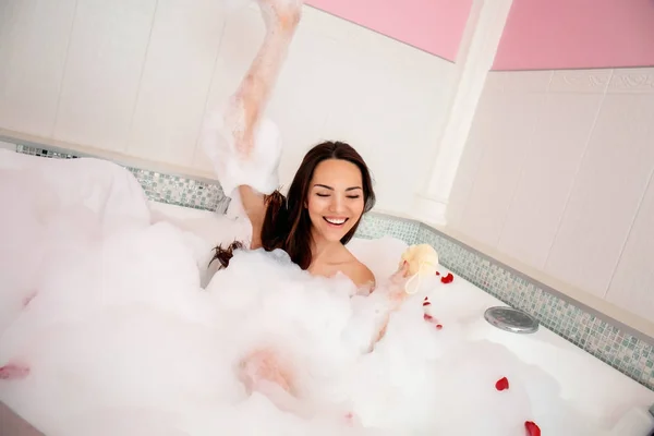 Mulher bonita relaxante na banheira com espuma — Fotografia de Stock