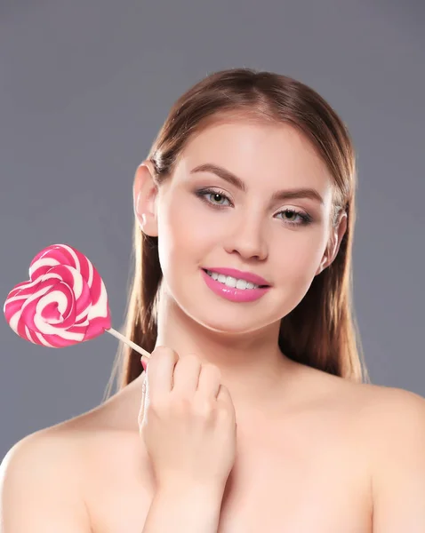 Piękna młoda kobieta z lollipop na kolor tła — Zdjęcie stockowe