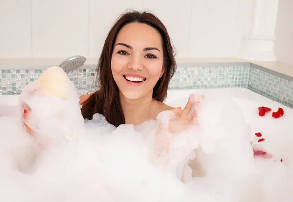 Wanita cantik santai di bak mandi dengan busa — Stok Foto