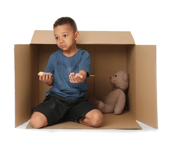 Lindo niño viviendo en caja sobre fondo blanco. Concepto de pobreza — Foto de Stock