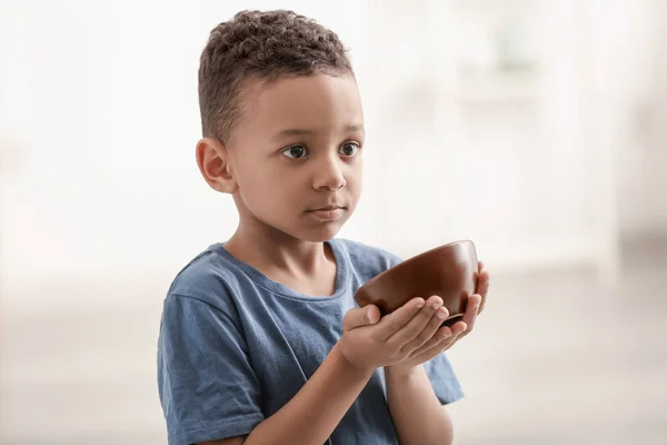 Милий маленький хлопчик з мискою на розмитому тлі. концепція бідності — стокове фото