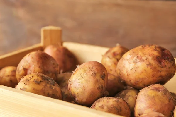 Caixa de madeira com batatas cruas — Fotografia de Stock