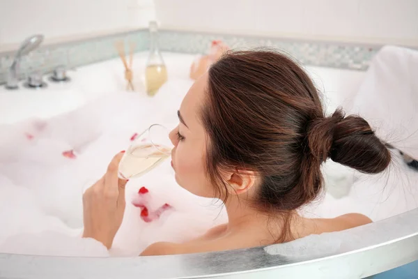 Красивая женщина с бокалом шампанского в ванной — стоковое фото