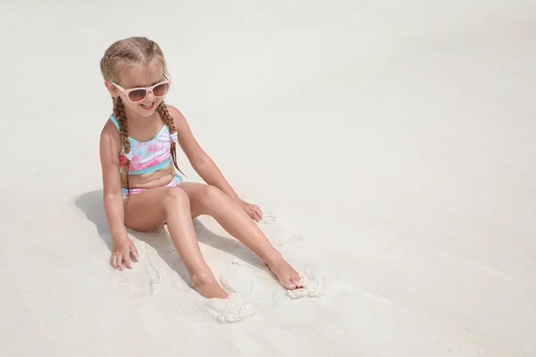 Niedliches kleines Mädchen sitzt am Strand — Stockfoto