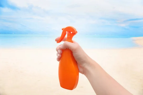 Ręka z butelką krem ochrony przeciwsłonecznej — Zdjęcie stockowe