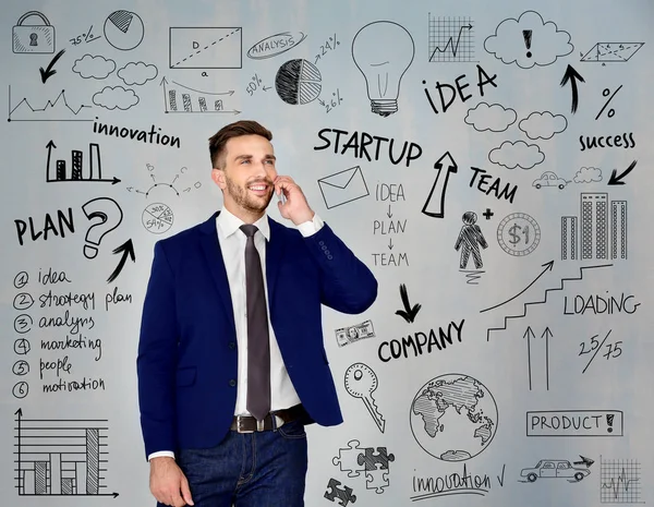 Joven hablando por teléfono y bocetos de ideas de negocios sobre fondo gris. Concepto de consulta — Foto de Stock