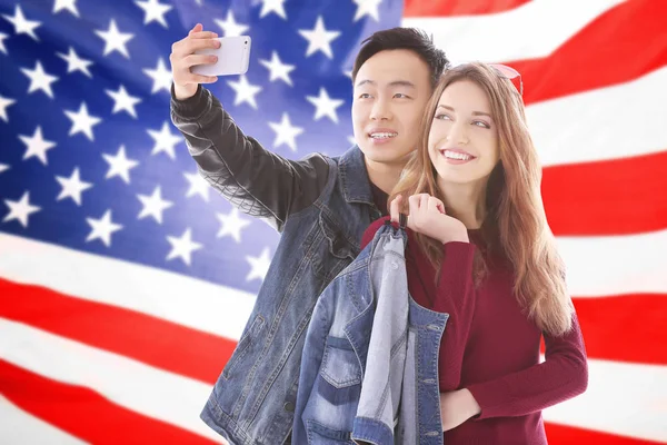 Young couple tacking selfie and USA flag on background — Stock Photo, Image