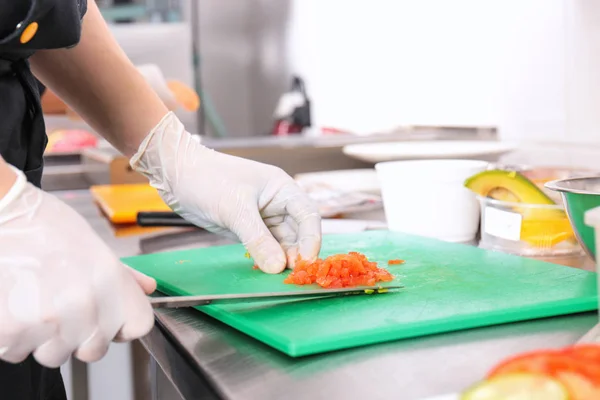 Vrouwelijke chef-kok cutting zalm aan boord — Stockfoto