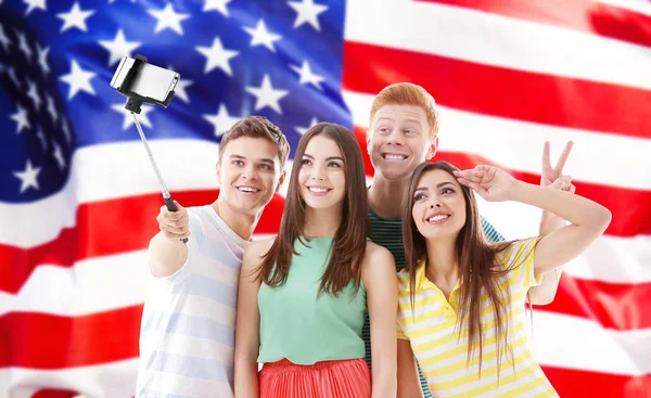 Amigos selfie tacking e bandeira dos EUA no fundo — Fotografia de Stock