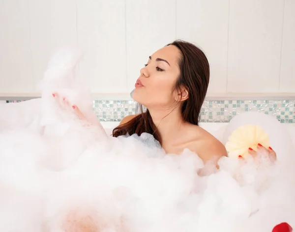 Bella donna rilassante nella vasca da bagno con schiuma — Foto Stock