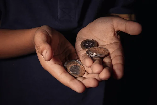 Händerna på liten pojke med mynt, närbild. Fattigdom-konceptet — Stockfoto