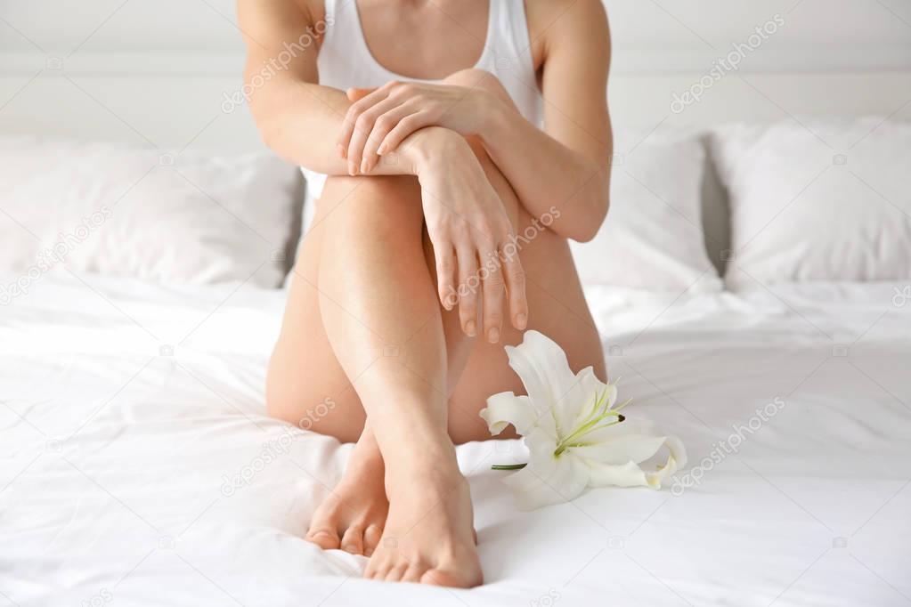 Young woman with flower on bed