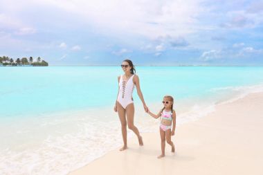 Kızı plajda kadınla
