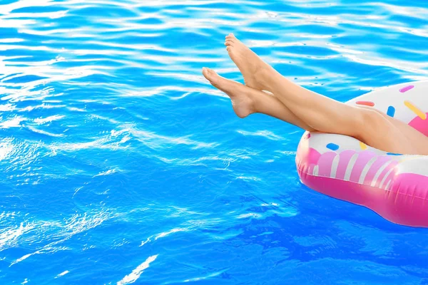 Jeune femme relaxant sur beignet gonflable dans la piscine — Photo